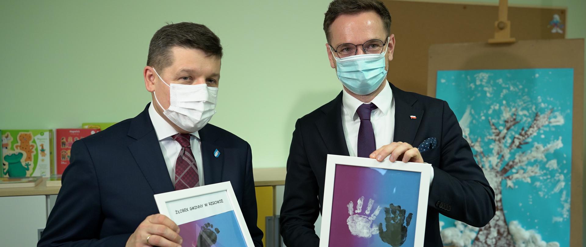 Wiceminister Waldemar Buda i Mateusz Kamińskiego - Burmistrza Rzgowa prezentują prace dzieci.