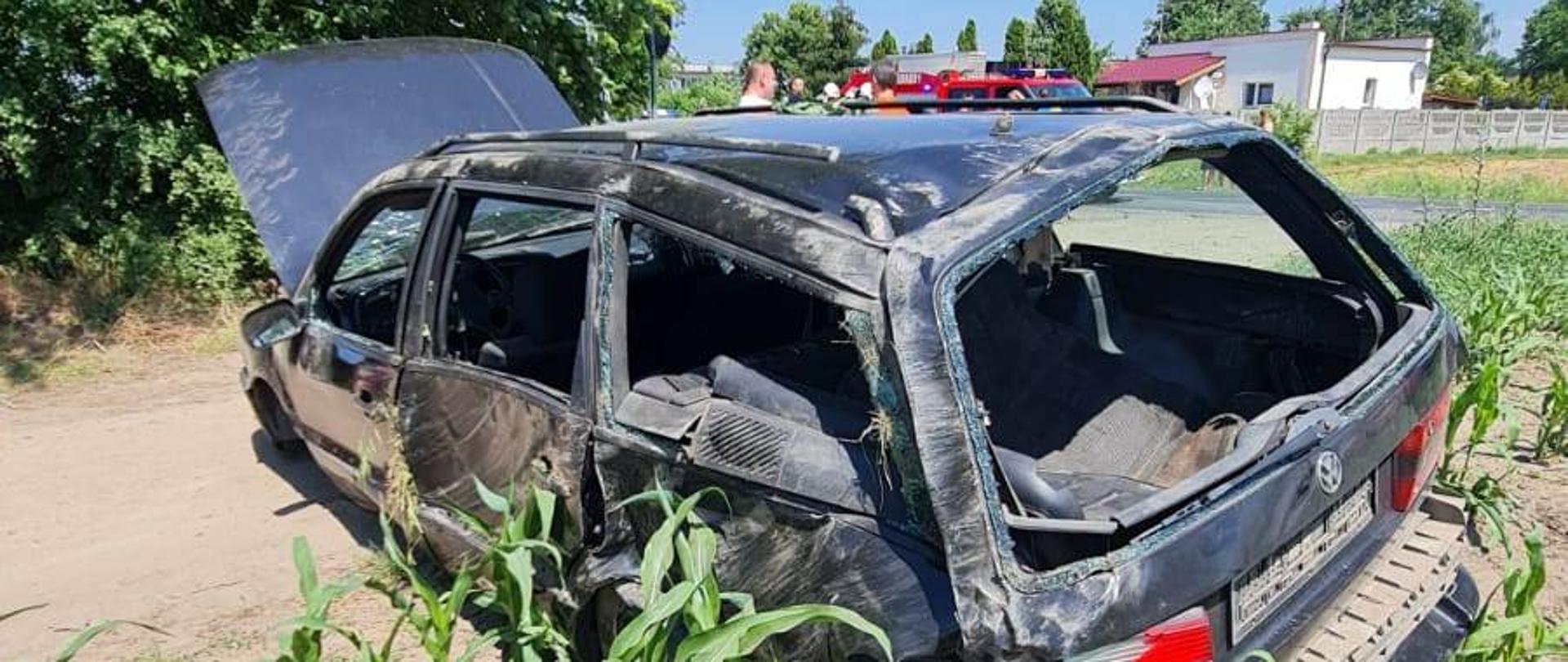 Widać uszkodzony samochód od strony kierowcy i tyłu