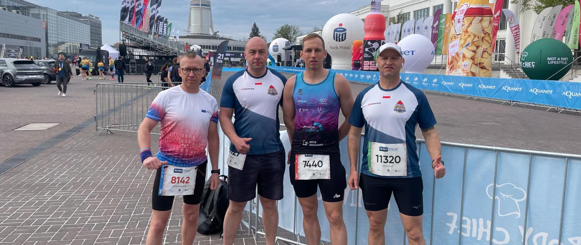 cztery osoby w ubraniach sportowych, z numerami startowymi