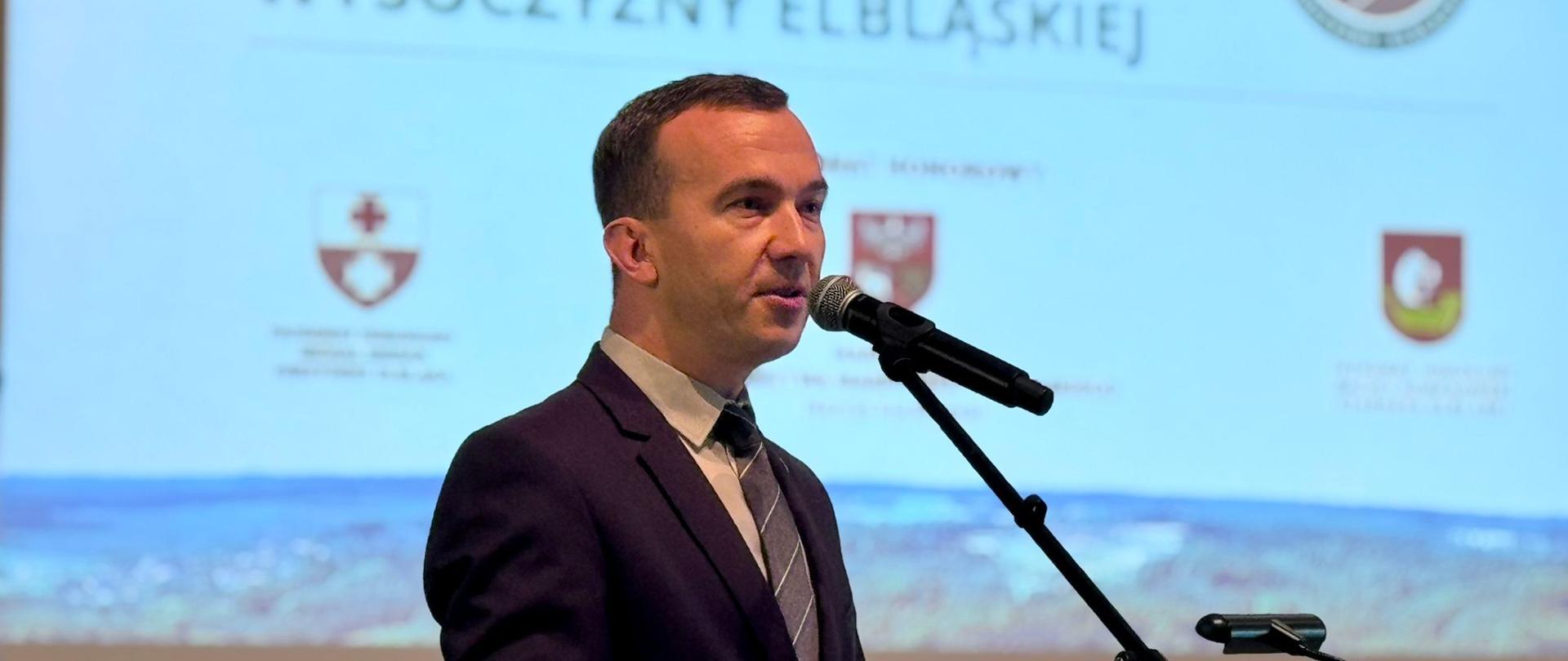 Mężczyzna przemawia przez mikrofon 