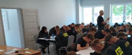 Słuchacze Kursu podstawowego OSP znajdujący się na w sali szkoleniowej podczas pisemnego egzaminu. 