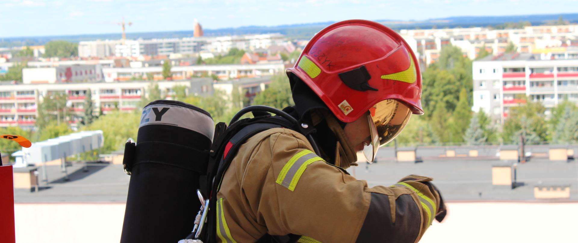 Strażak na drabinie mechanicznej na zewnątrz budynku