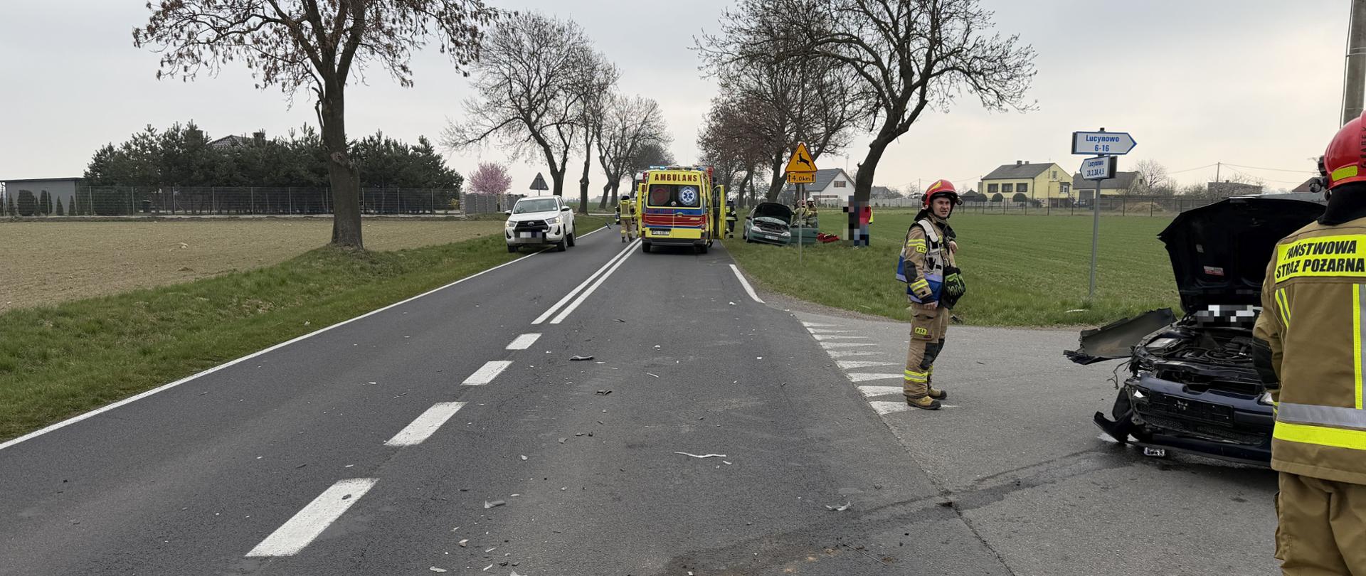 Uszkodzone samochody wokół strażacy oraz inne służby 