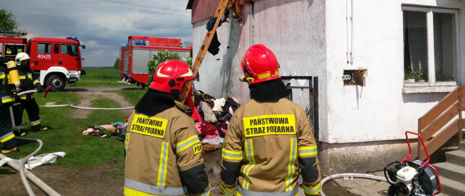 Na zdjęciu strażacy podczas rozwinięcia bojowego - z linią wężową wprowadzoną do budynku