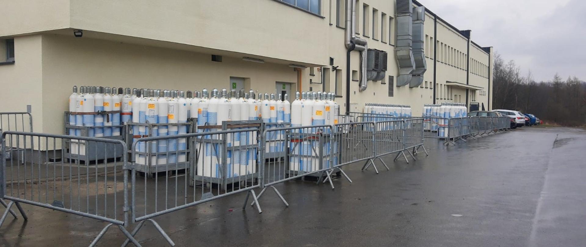 Butle z tlenem wspomagającym pacjentów chorych na COVID-19 ustawione pod budynkiem szpitala.