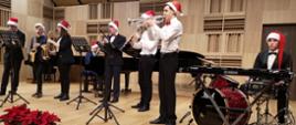 Oktet instrumentalny na scenie w czapkach Mikołajów - koncert świąteczny.