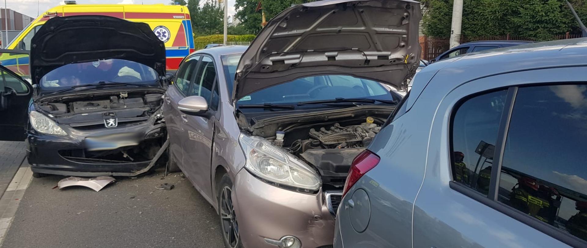 Trzy samochody osobowe jeden za drugim na poboczu.