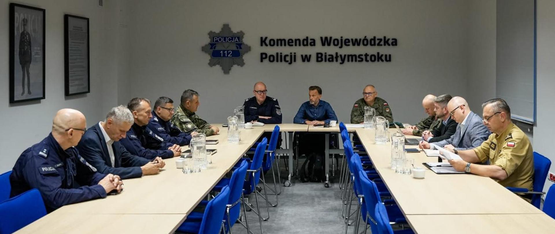 Sztab kryzysowy w związku z naruszeniem przestrzeni powietrznej - przedstawiciele służb woj. podlaskiego podczas posiedzenia siedzą przy stole