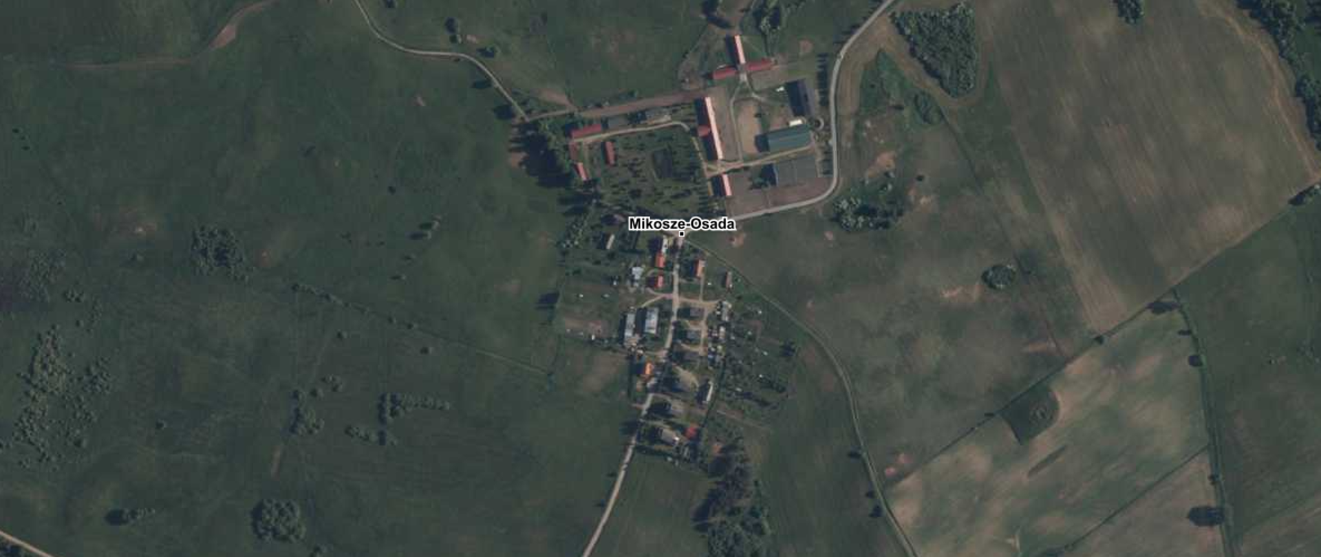 Ilustracja przedstawiająca zrzut ekranu z serwisu www.geoportal.gov.pl z zaznaczoną na podkładzie ortofotomapy lokalizacją urzędowej nazwy miejscowości Mikosze-Osada, wieś.