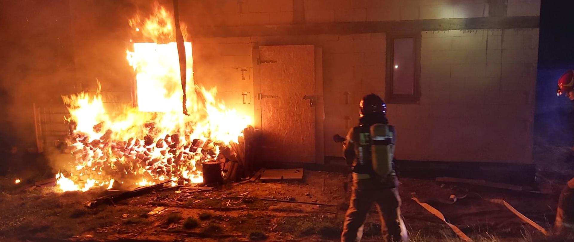 Strażacy gaszą pożar budynku.