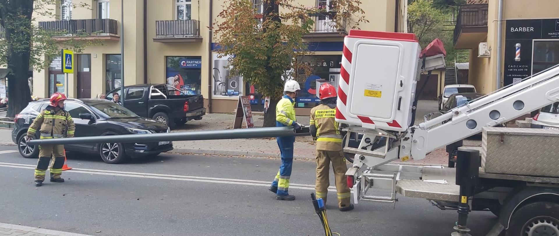 Strażacy usuwają latarnie uliczną