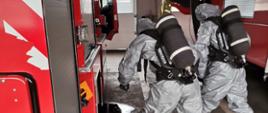 Dwaj strażacy ubrani w specjalistyczne ubrania ochronne podczas warsztatów z ratownictwa chemiczno-ekologicznego