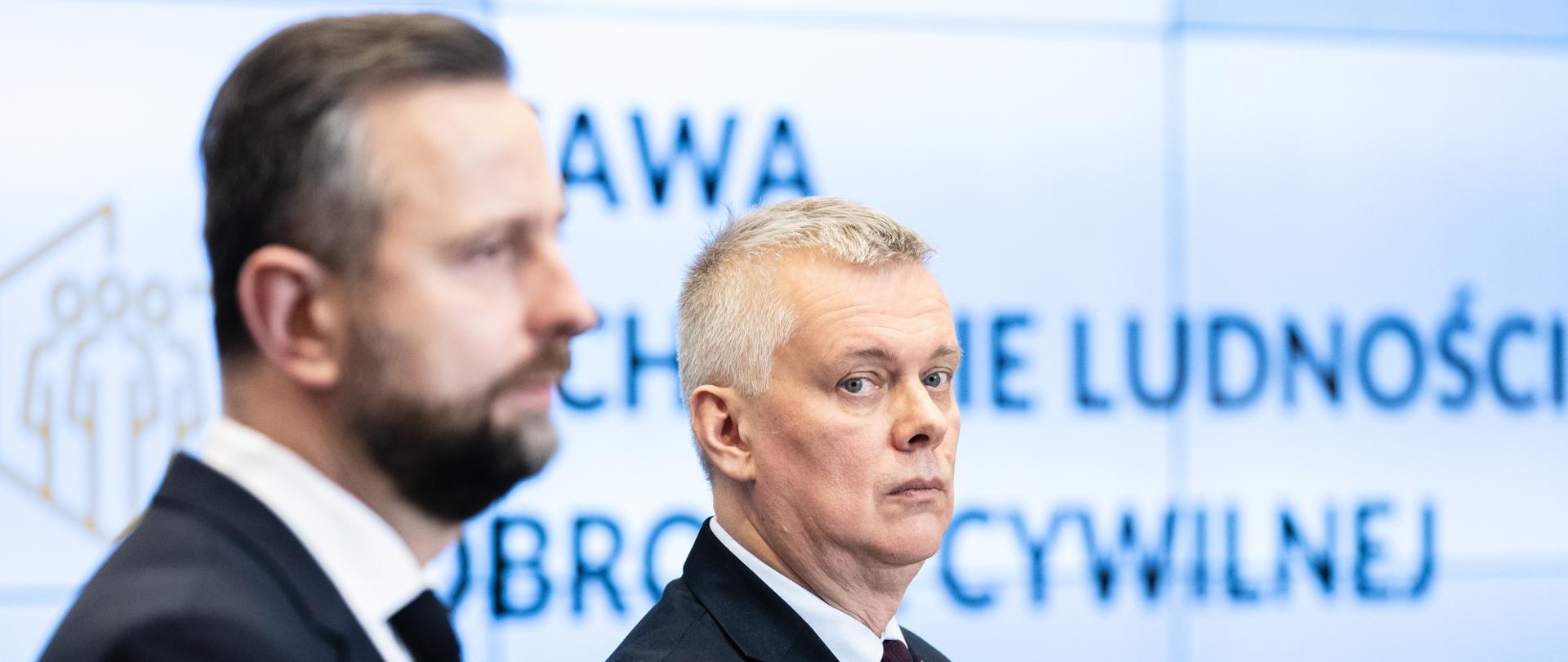 Szef MSWiA Tomasz Siemoniak oraz wicepremier, minister obrony narodowej Władysław Kosiniak-Kamysz na konferencji prasowej. Minister Siemoniak patrzy w obiektyw. Minister Kosiniak-Kamysz z profilu.