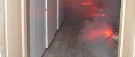 Ćwiczenia w Domu Kultury w Rawiczu. Jedno z pomieszczeń na drugiej kondygnacji budynku. W pomieszczeniu zasymulowano pożar. W tym celu użyto flar ostrzegawczych oraz zadymiarki. Pomieszczenia jest częściowo wypełnione dymem.