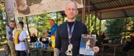 St. ogn. Mariusz Bielawski w stroju sportowym z dyplomem i srebrnym medalem za ukończenie ukończenia Setki Komandosa. w pierwszej setce uczestników.