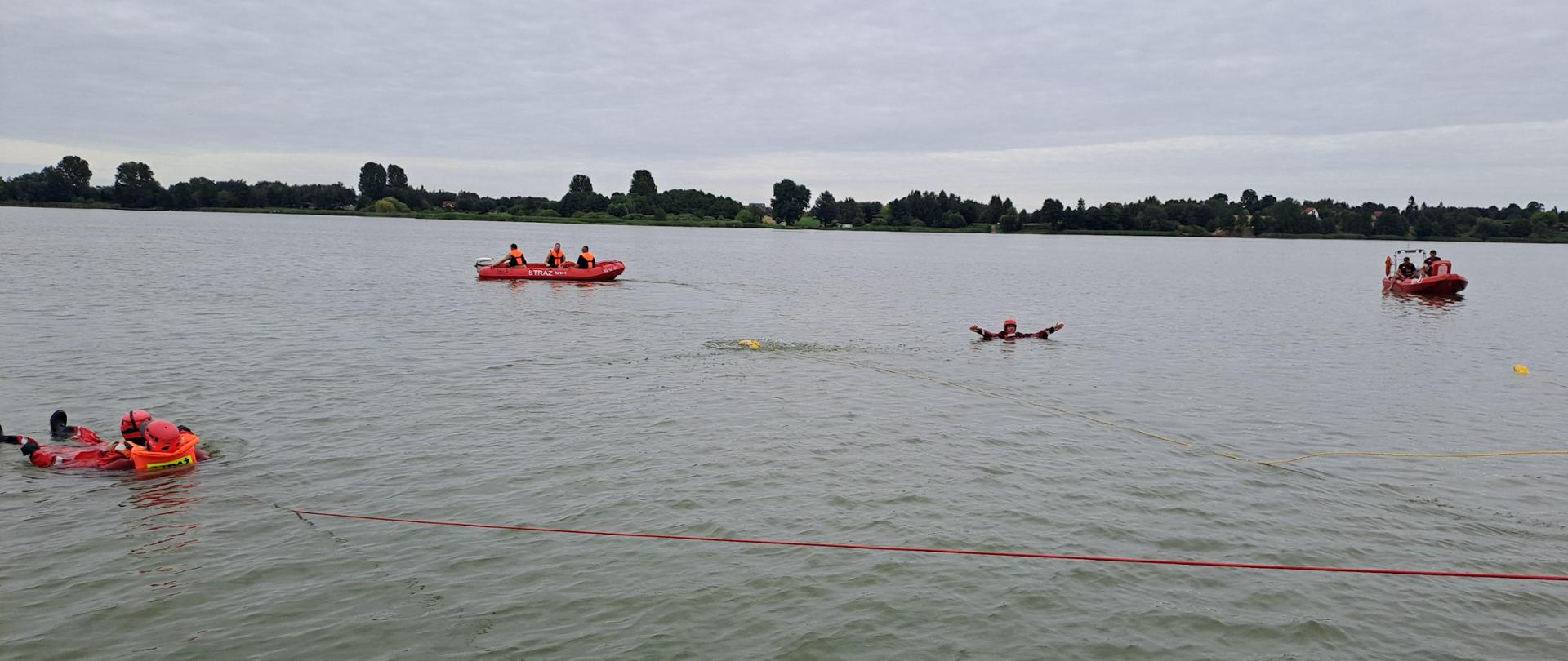 Zdjęcie przedstawia plażę gminną w Głuszynie oraz strażaków PSP oraz OSP podczas ćwiczeń na jeziorze Głuszyńskim