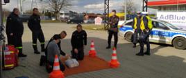 Na zdjęciu strażacy oraz policjanci uczą kierowcy udzielania pierwszej pomocy na fantomie szkoleniowym