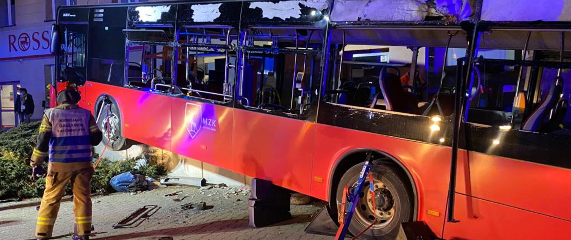 Na zdjęciu strażak przed autobusem