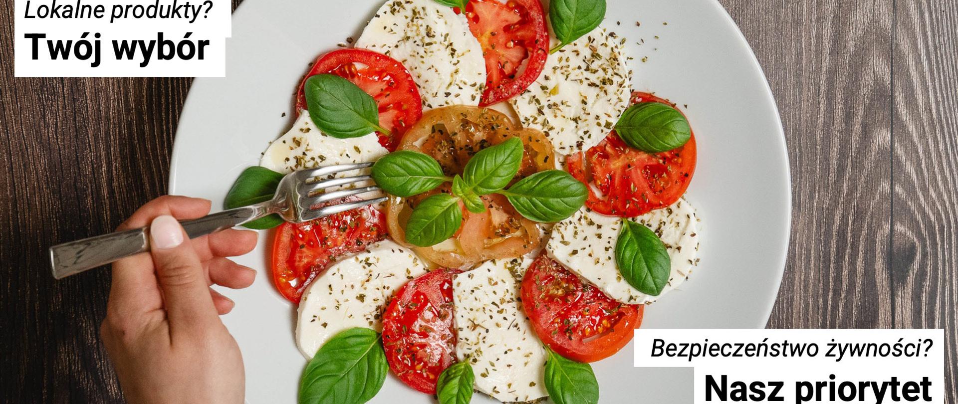 Zdjecie przedstawia talerz z plasterkami pomidora i białego twarogu, posypane zielonymi liśmi bazylii