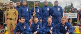 Na zdjęciu drużyna OSP Bystrowice ustawiona do zdjęcia grupowego wraz z opiekunem drużyny. Wszyscy ubrani są w umundurowanie koszarowe.