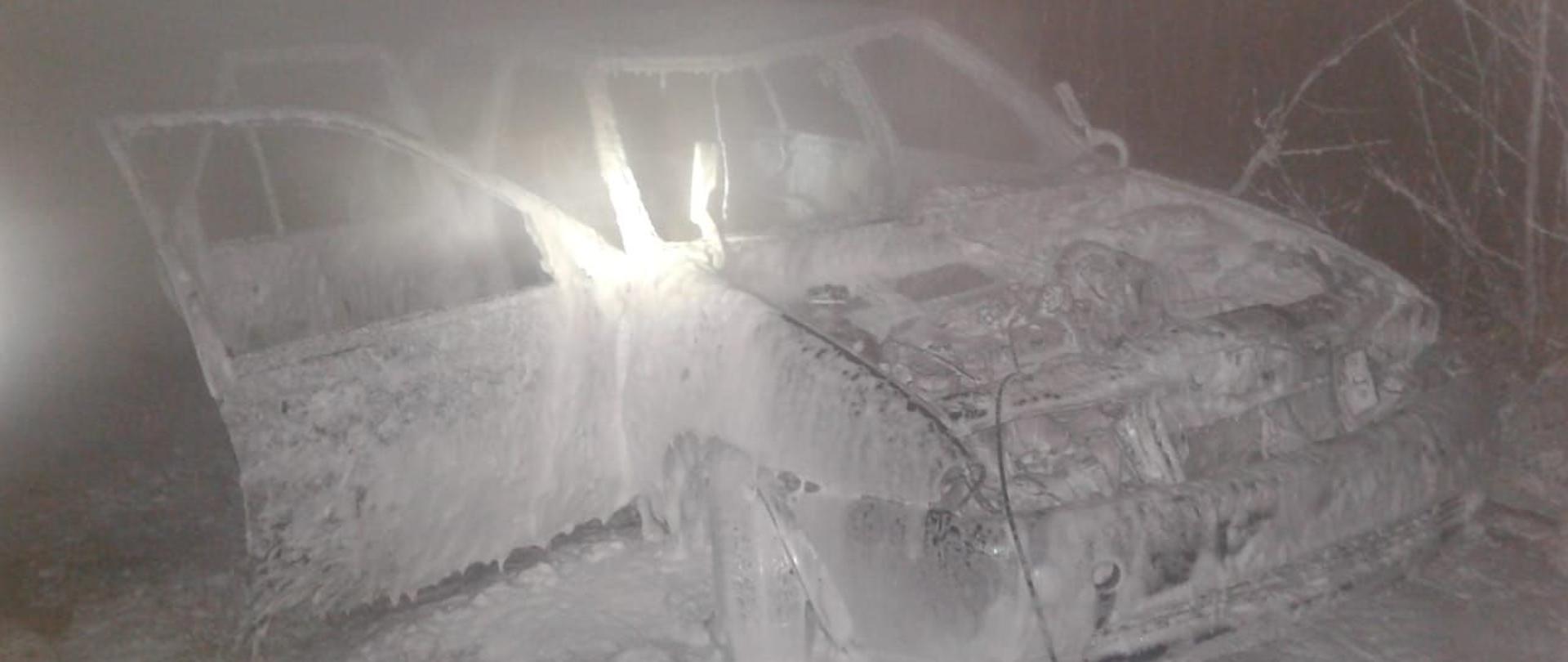 Zdjęcie przedstawia ugaszony pożar samochodu osobowego. Do gaszenia pojazdu strażacy z Jednostki ratowniczo gaśniczej użyli piany sprężonej. Cały samochód oblepiony jest białą pianą. 