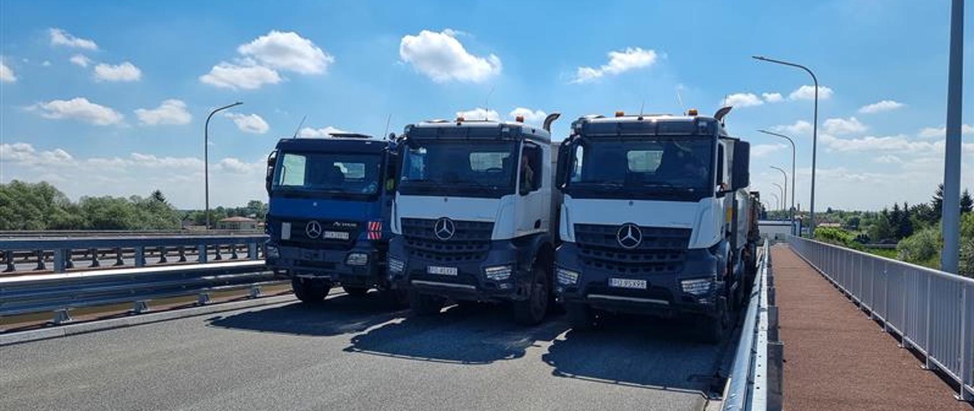 Most w Sandomierzu - próba obciążenia. Trzy samochody ciężarowe ustawione na moście obok siebie na całej szerokości jezdni. 