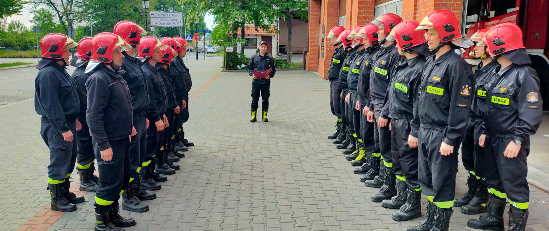 Na zdjęciu widać uroczystą zmianę służby. Dwie zmiany służbowe zwrócone do siebie frontem stoją w dwuszeregu. Zastępca Komendanta odczytuje decyzję o przyznaniu funkcjonariuszowi nagrody Wielkopolskiego Komendanta Wojewódzkiego