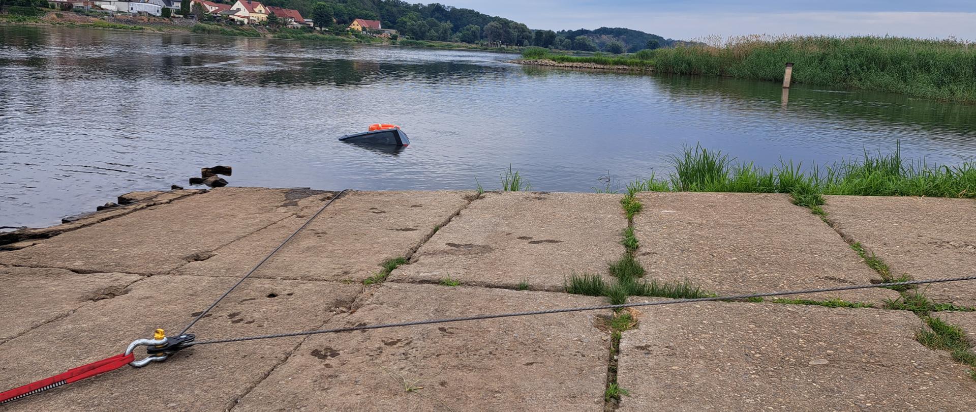 Układ linowy podpięte do samochodu zanurzonego w wodach rzeki.