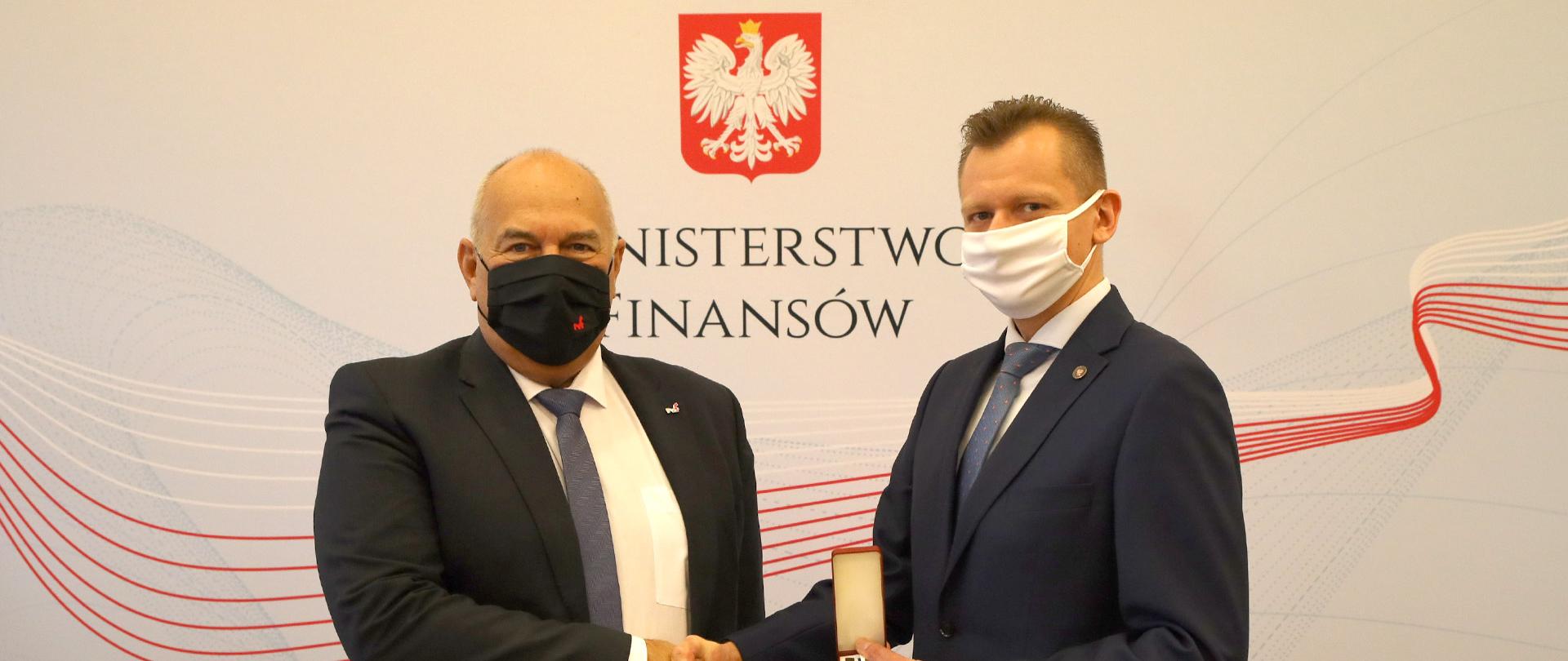 Mariusz Łukasik, zastępca dyrektora Biura Kadr Płac i Budżetu odbiera wyróżnienia za zasługi dla finansów publicznych