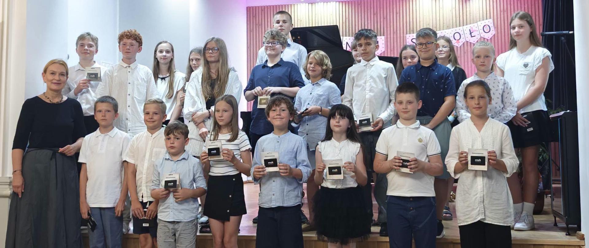 Galeria 20 zdjęć z uroczystego zakończenia roku szkolnego w Państwowej Szkole Muzycznej I stopnia w Kłodzku, które odbyło się 26 czerwca 2026 roku. Fotografie przedstawiają występy uczniów, wręczenie nagród oraz wspólne pamiątkowe zdjęcia uczestników uroczystości.