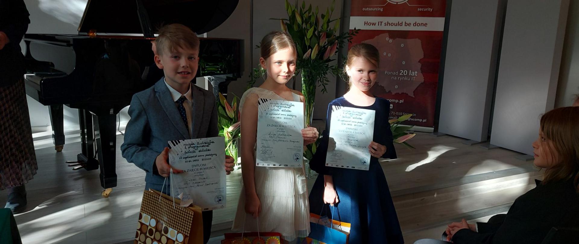 Na zdjęciu nagrodzeni uczniowie z nagrodami i dyplomami