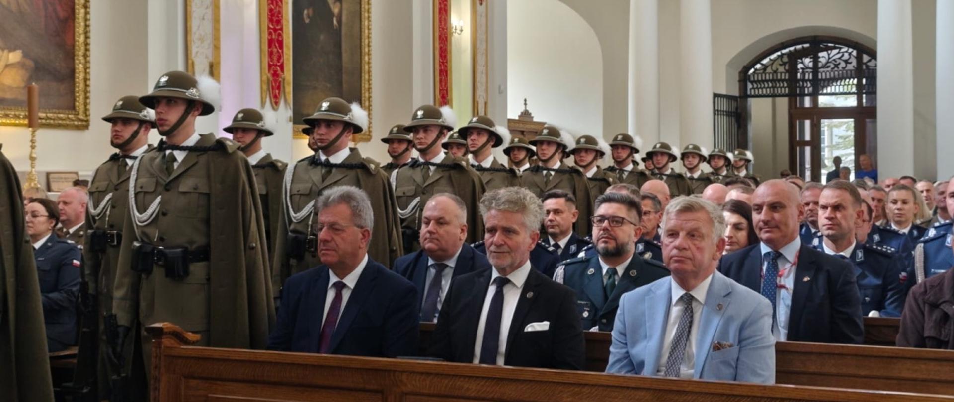 W kościele w ławkach siedzi grupa osób