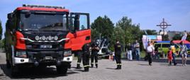 Pojazd ratowniczo gaśniczy, strażacy oraz uczestnicy na festynie z okazji obchodów św. Krzysztofa przy Parafii Chrystusa Miłosiernego w Inowrocławiu 
