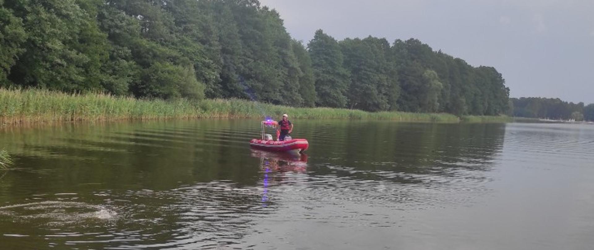 Strażak na łodzi prowadzi poszukiwania mężczyzny. 