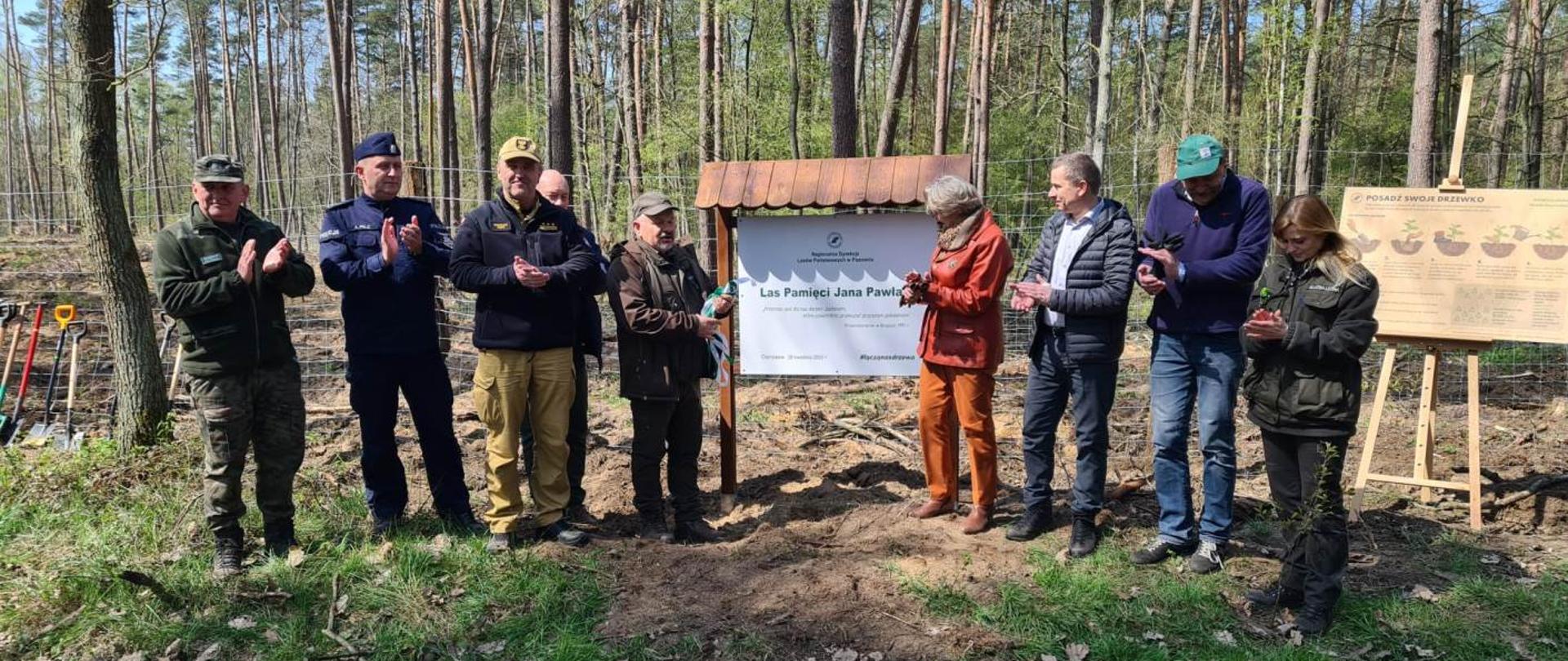 Widać przedstawicieli służb i władz lokalnych podczas odsłaniania tablicy