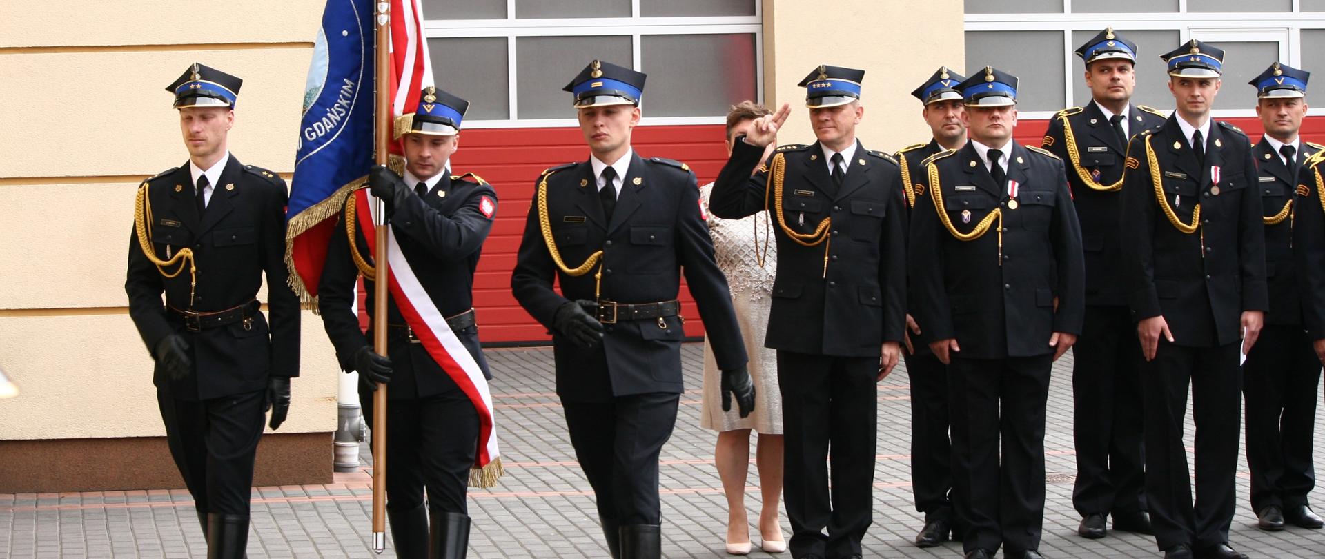 Na zdjęciu widzimy poczet sztandarowy Komendy Powiatowej PSP w Pruszczu Gdańskim oraz strażaków stojących w pododdziale podczas OBCHODów DNIA STRAŻAKA ORAZ JUBILEUSZU 30-LECIA PSP