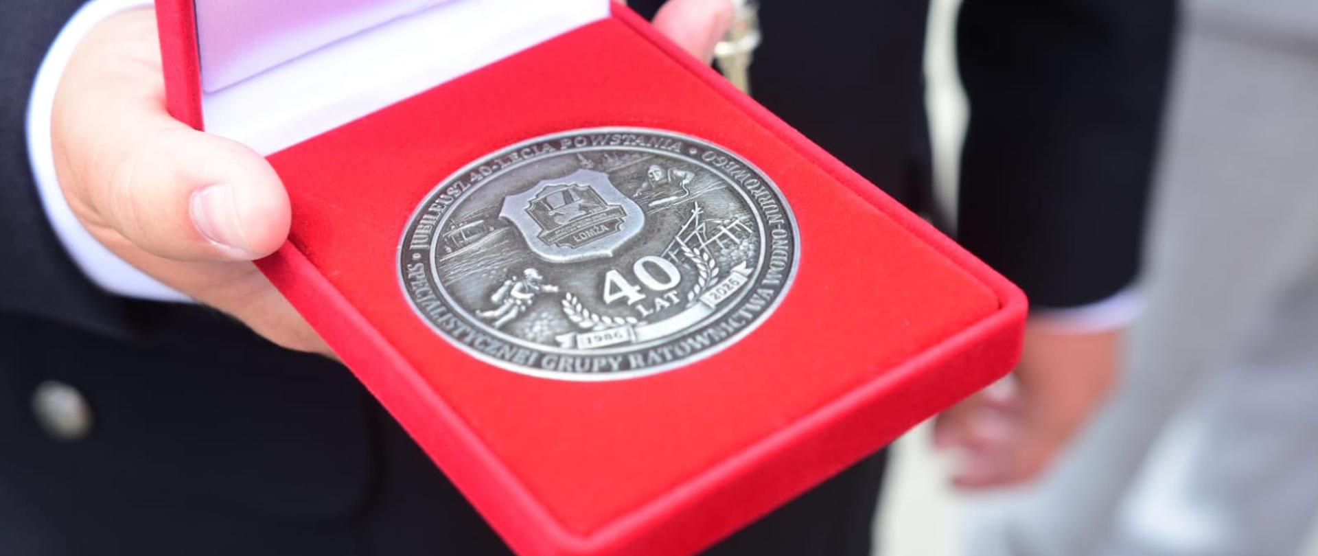 Pamiątkowy medal jubileuszowy z okazji 40-lecia Specjalistycznej Grupy Ratownictwa Wodno-Nurkowego „Łomża”, symbolizujący wieloletnią służbę, profesjonalizm oraz zaangażowanie ratowników w zapewnianie bezpieczeństwa na wodach regionu