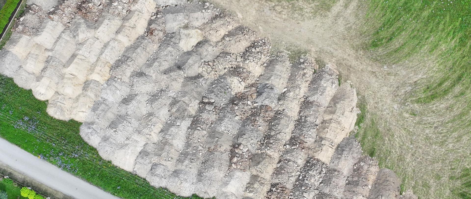 Hałdy ziemi widziane z lotu ptaka otoczone trawą.