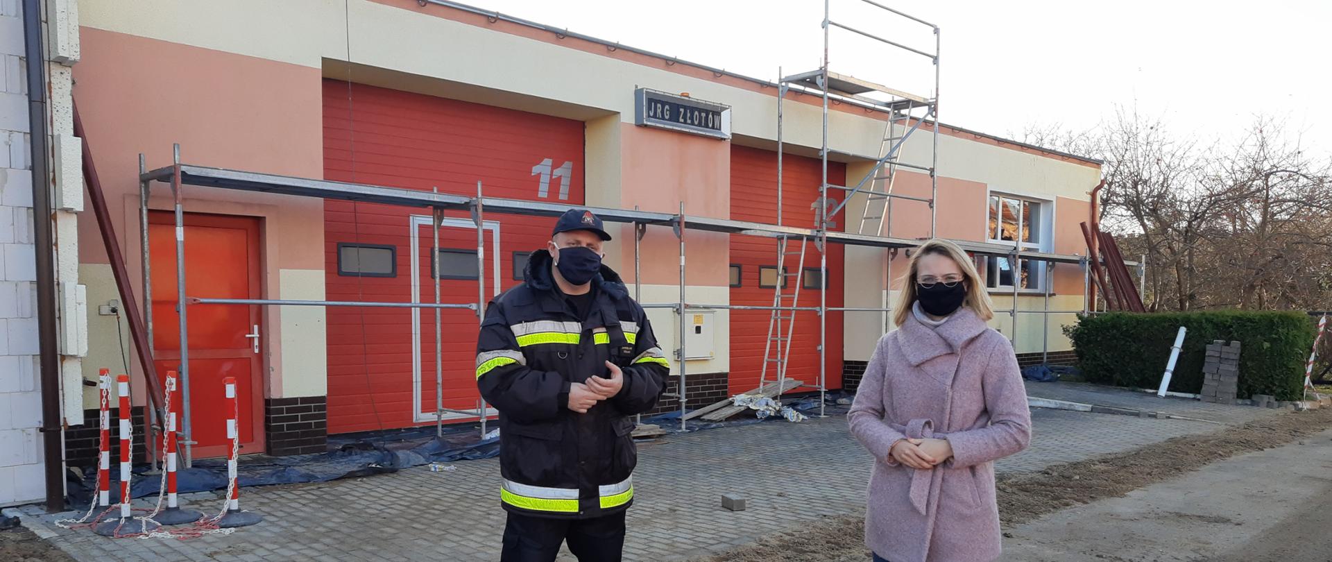 Pani Poseł z komendantem na tle modernizowanego obiektu