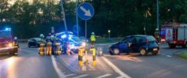 Na zdjęciu wrak pojazdu po uderzeniu czołowym w słup, obok samochody strażackie oraz strażacy wraz z policjantami