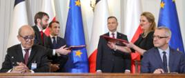 Moment podpisania deklaracji - przy stole (po lewej) minister Minister Europy i Spraw Zagranicznych Francji Jean-Yves Le Drian, (po prawej) Minister cyfryzacji RP Marek Zagórski. Za nimi stoją: (po lewej ) Prezydent Francji Emmanuel Macron, (po prawej) Prezydent RP Andrzej Duda