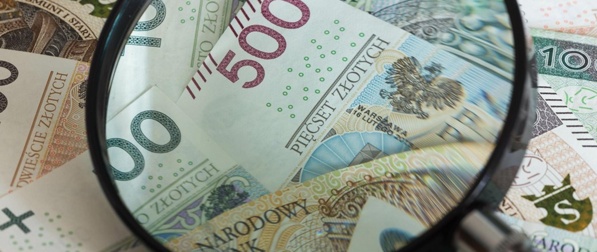 Banknoty pod szkłem powiększającym