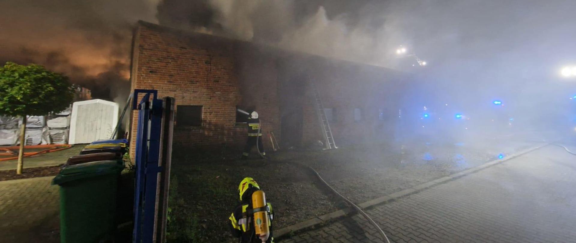 widoczne miejsce zdarzenia oraz strażacy podczas działań gaśniczych.