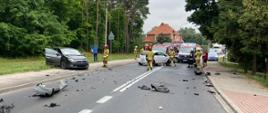 Na zdjęciu widać miejsce zdarzenia rozbite pojazdy oraz służby ratownicze 