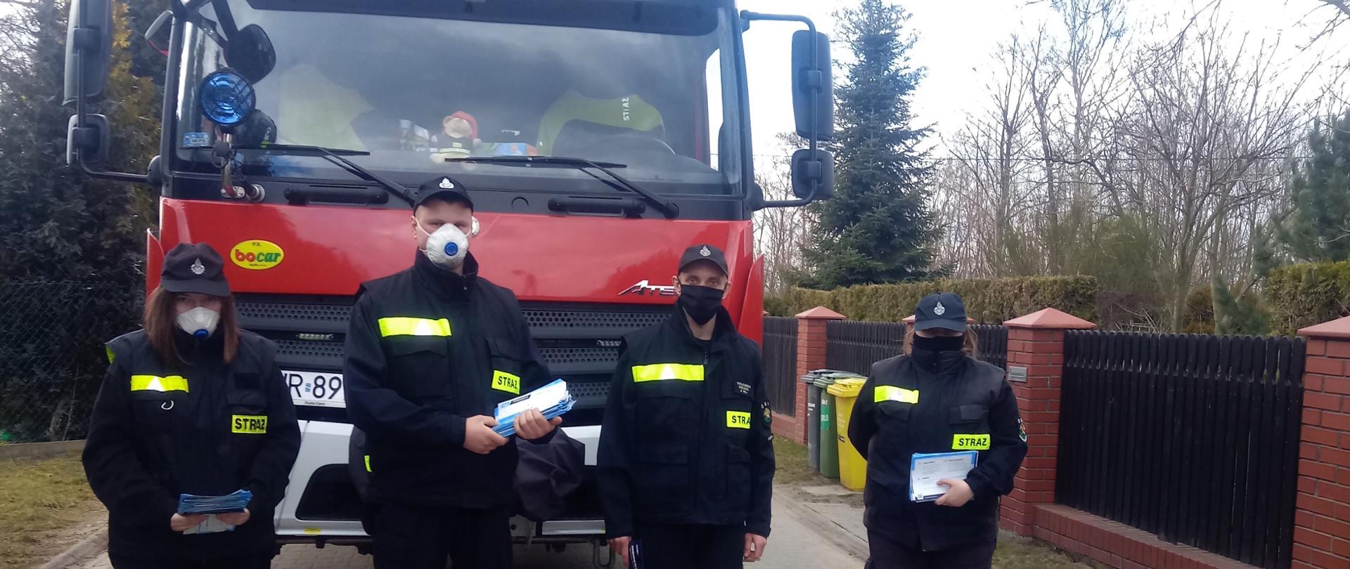 Strażacy z ulotkami przy samochodzie 