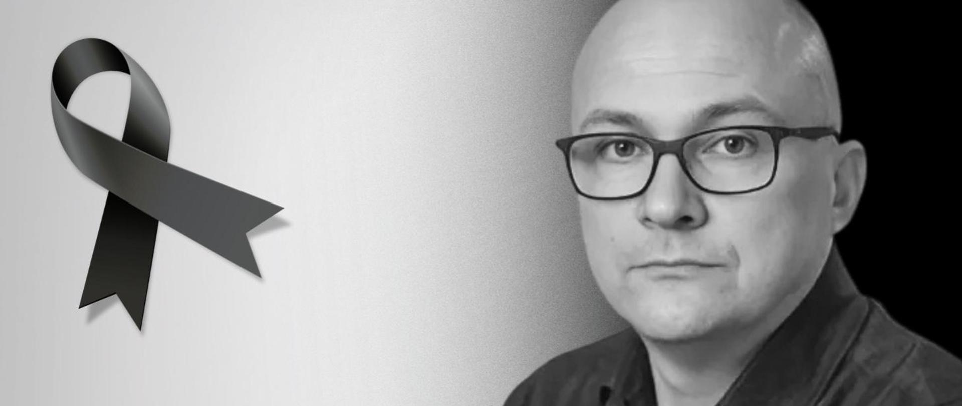 Czarno-biała grafika, żałobna wstążka i twarz mężczyzny na szarym tle.