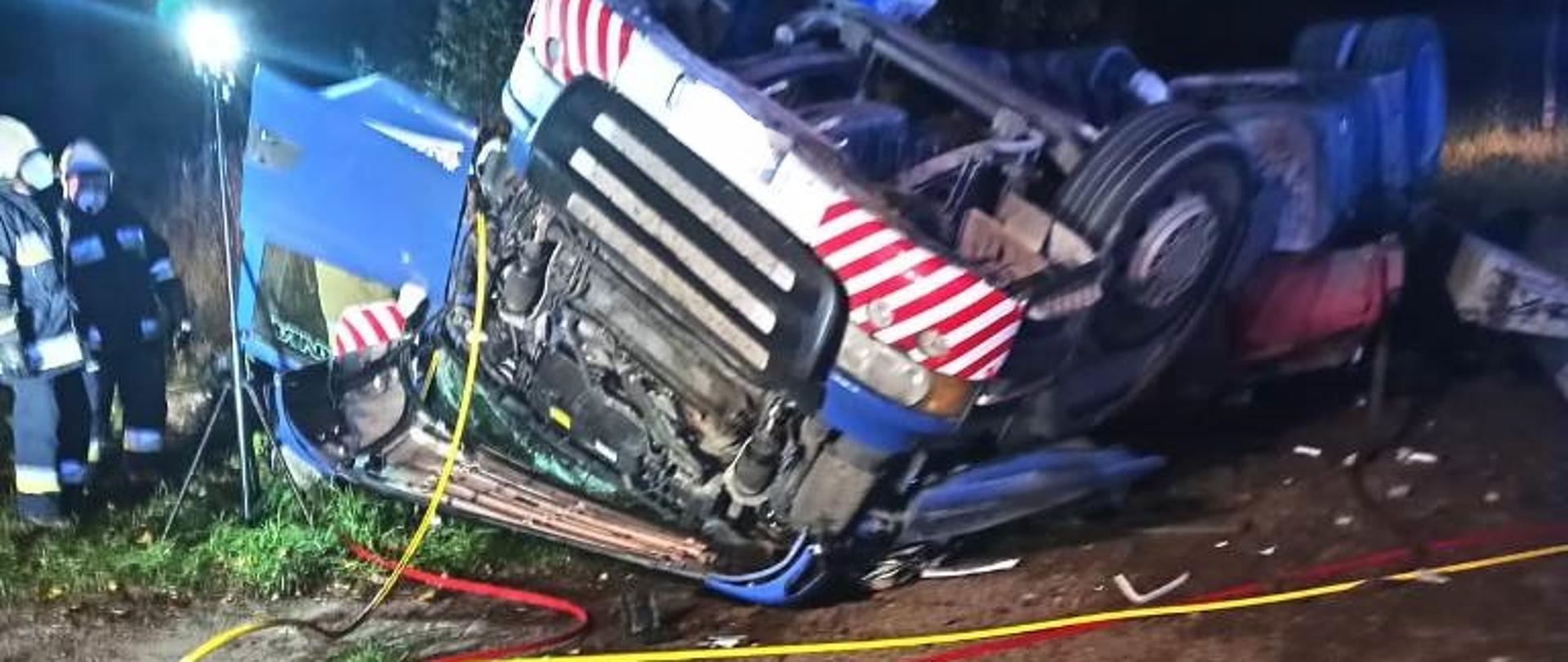 Strażacy używający narzędzi hydraulicznych w celu wydobycia kierowcy z kabiny samochodu ciężarowego