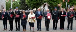 Widok z przodu. Osoby wyróżnione przez komendanta powiatowego PSP specjalnymi pamiątkowymi podziękowaniami.
