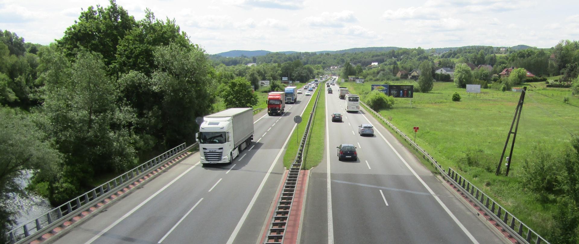 Droga Krajowa nr 7, zakopianka, Głogoczów, widoczne obie jezdnie, w tle kładka dla pieszych w formie litery V. 