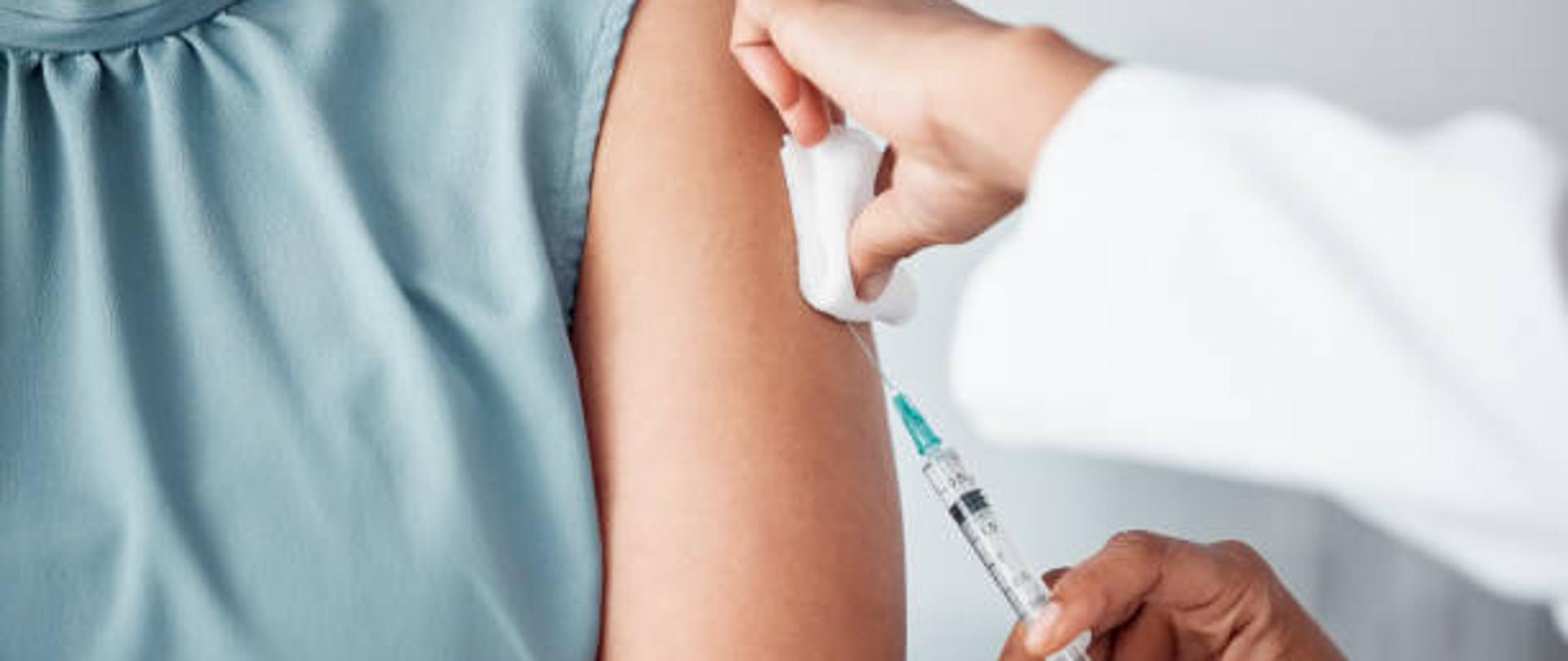 Hands, medical and doctor with patient for vaccine in a clinic for healthcare treatment for prevention. Closeup of a nurse doing a vaccination injection with a needle syringe in a medicare hospital.